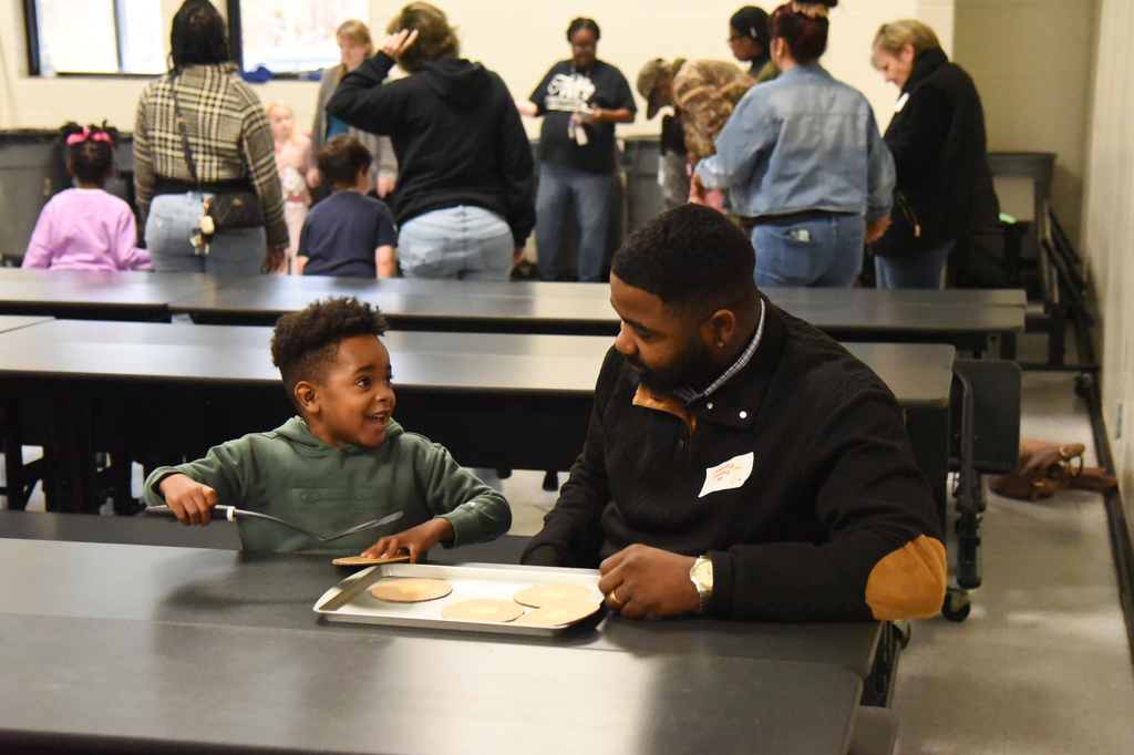 student flipping pretend pancakes