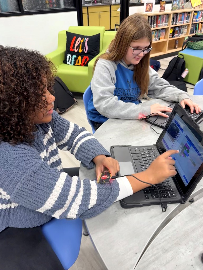 Students explore different hands on robots in the school library. 