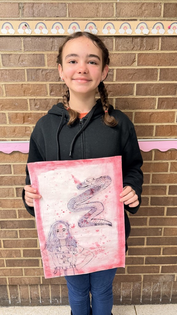 Student standing in front of brick wall holding surrealism self portrait