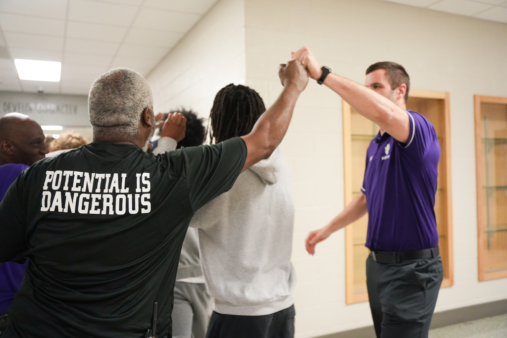 staff fist-bumps coach
