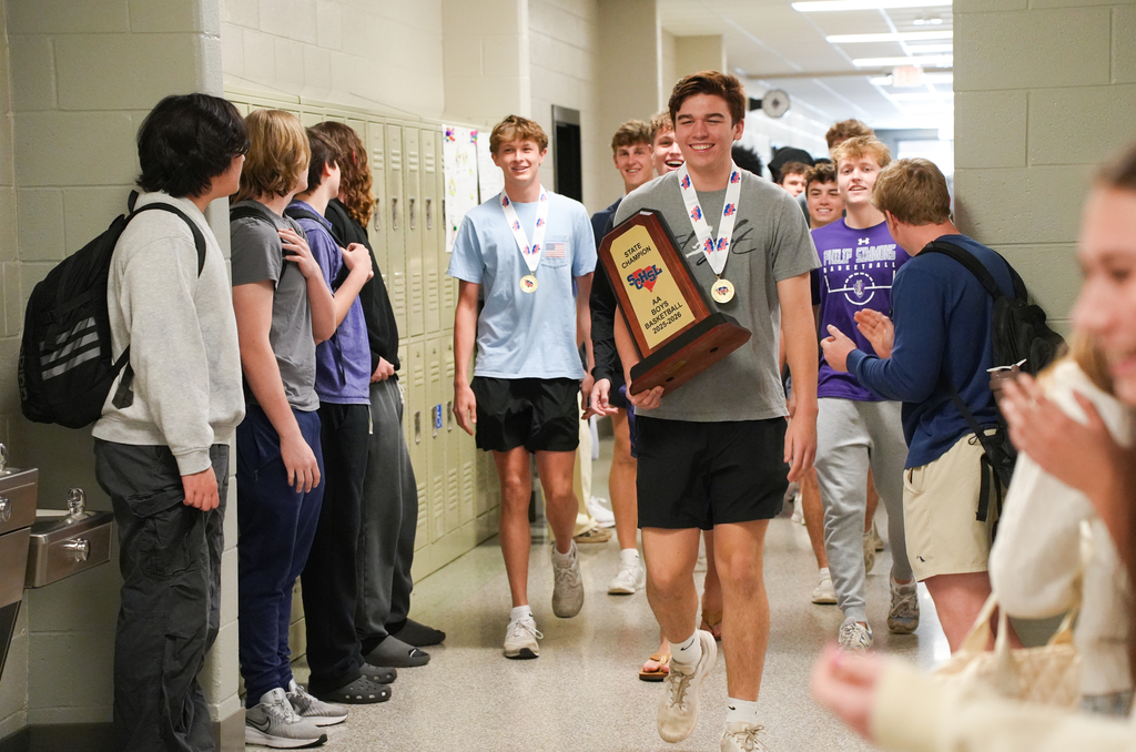 boys basketball team walking halls with trophy