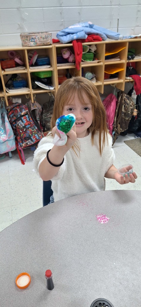 One student showing her sparkly green slime to the camera