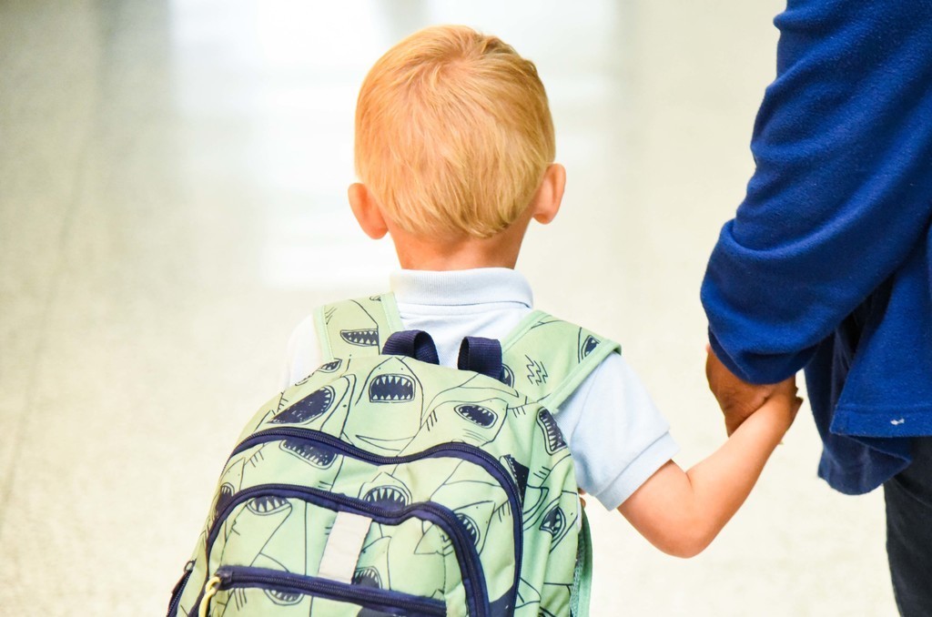 student walking down the hallway with a backpack