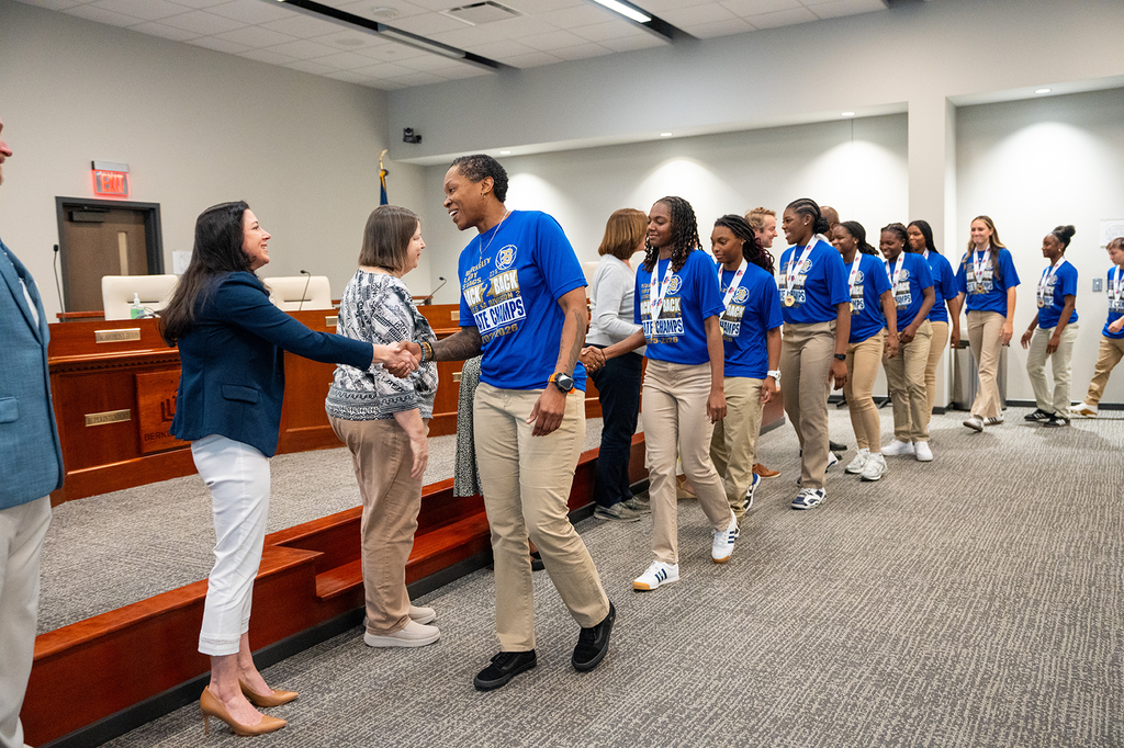 Coach Peace and BHS girls basketball team shaking board members' hands