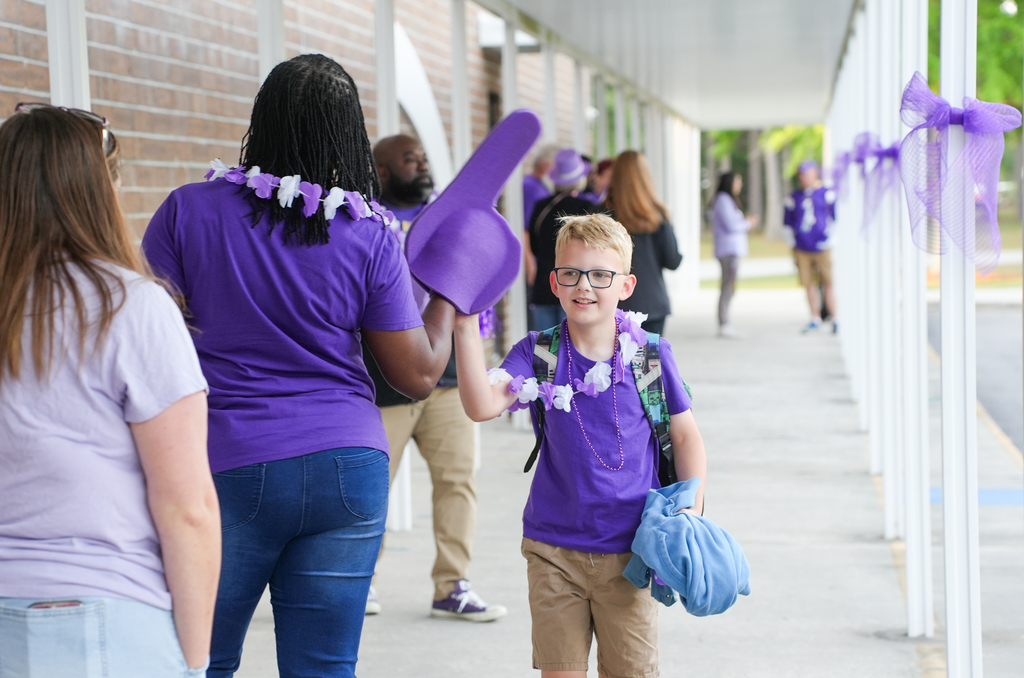 students high-fiving staff