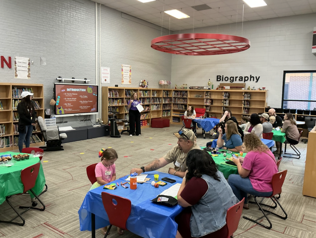 Group photo of parents and kids sitting around the HE Bonner library while teachers present about kindergarten