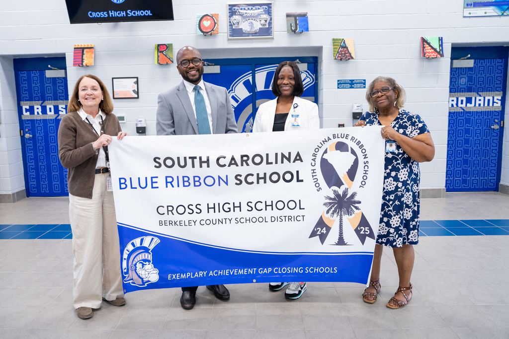 Five adults hold a banner reading "South Carolina Blue Ribbon School" at Cross High.