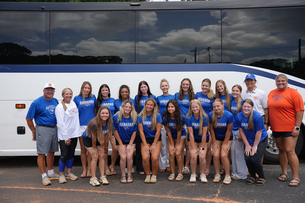 Group of athletes in blue shirts standing in two rows, two men and two women in front.