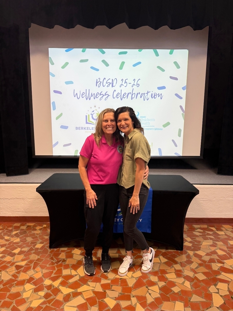 Two women posing in front of a screen that reads "BGSD 25-26 Wellness Celebration" at an event.