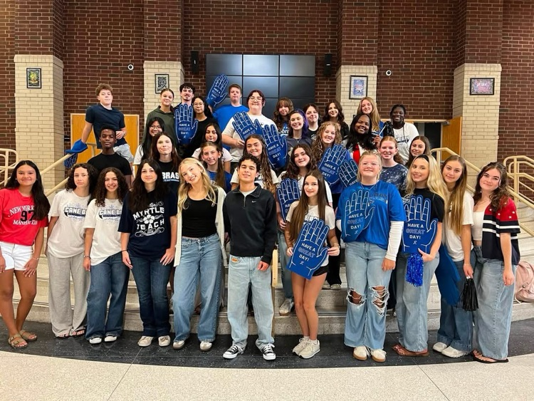 students standing in the commons ready for high five Friday