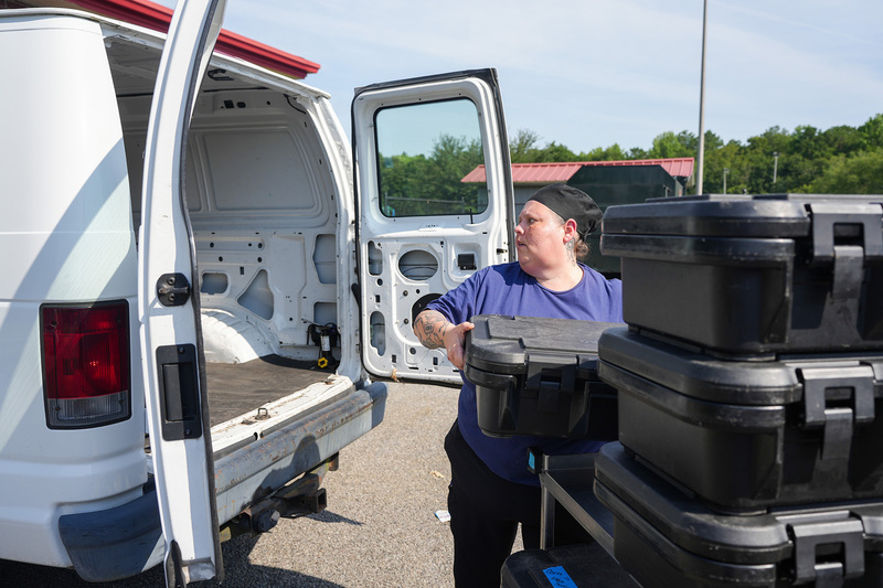 kasee loading lunch boxes into van