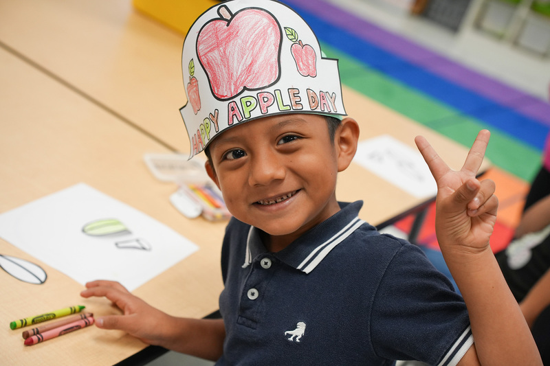 child with apple hat