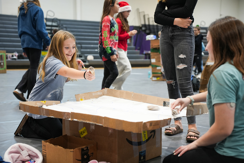 girls playing cardboard air hockey