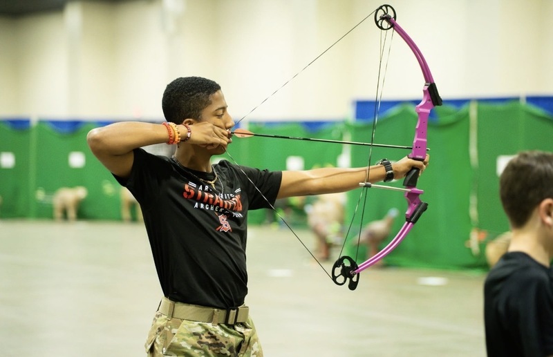 student shooting a bow