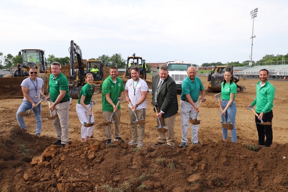 image of superintendent and staff members breaking ground on new turf at musselman high school