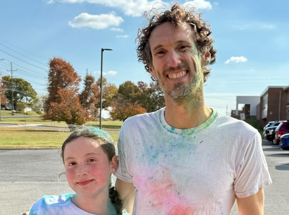 Teacher Mr. Malcolm following the color run with a student