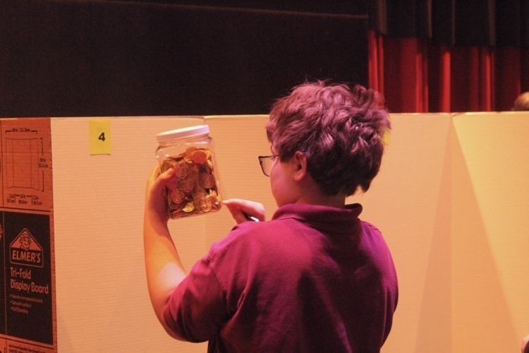 student counting coins in a jar