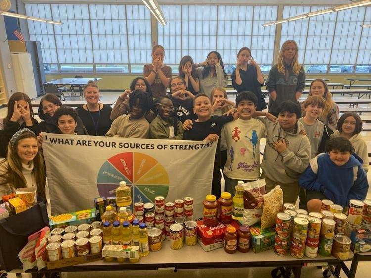 image of students showcasing food collected for food drive