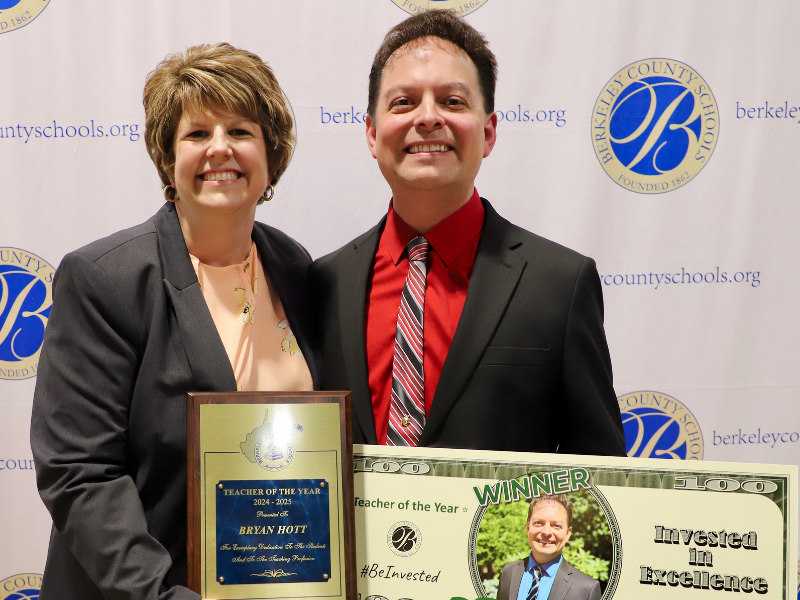 bryan hott receiving teacher of the year plaque from principal beth mccoy