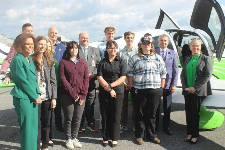 picture of people in front of a plane