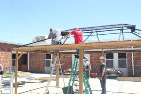 A group of volunteers build a gazebo in Mill Creek's courtyard