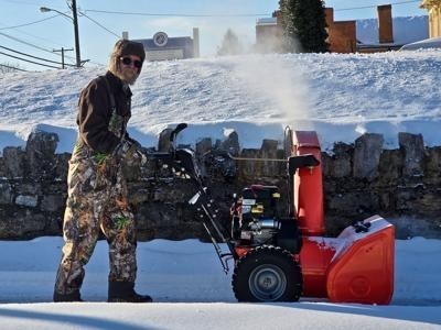 Martinsburg resident Kevin Mumma clears away snow at Berkeley County Schools building Wednesday.