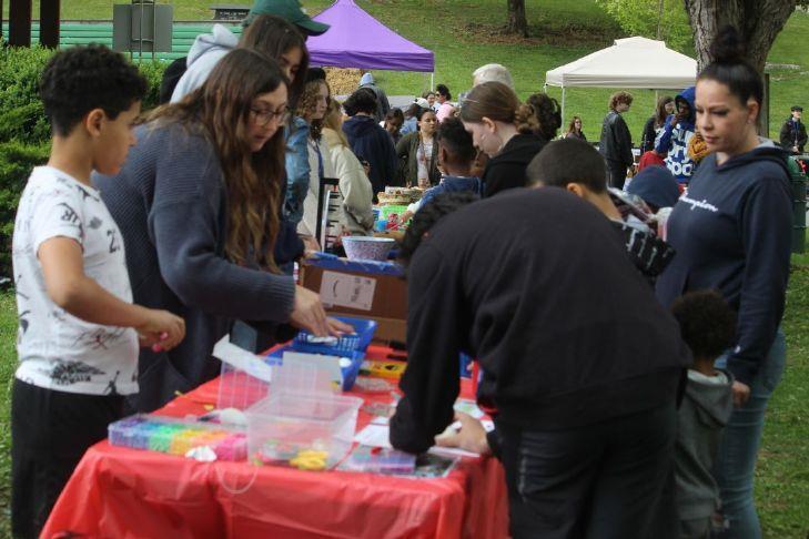 students at a fair looking at items on a table
