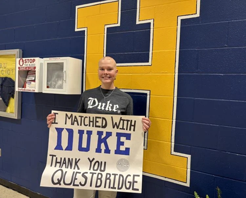 Caitlin Hall with the sign she made for er older sibling as she now celebrates her full ride scholarship to Duke University.