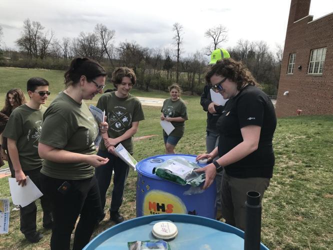 MHS Stormwater 2 Melissa Gantt, Nick Cole and Thomas Joy talk with the City of Martinsburg Stormwater Management team about the rain barrel.