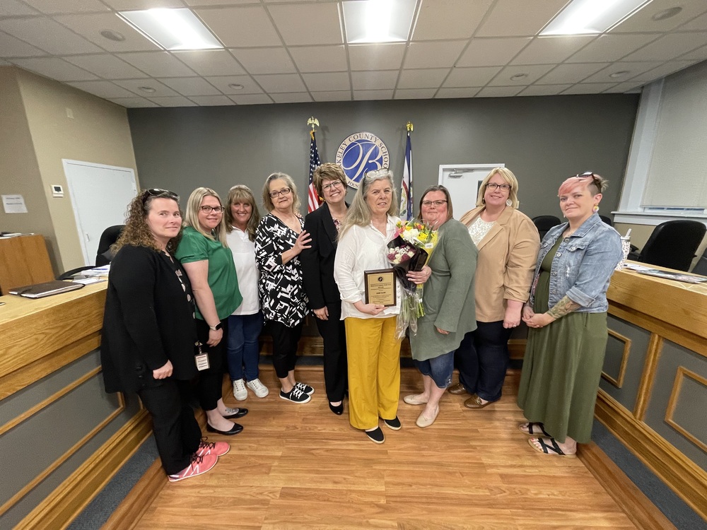 image of diane blake receiving the distinguished service award from principal and board members