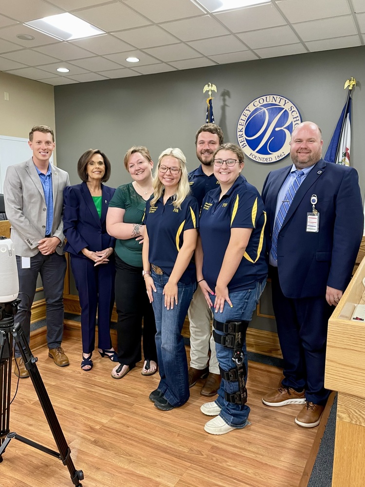 image of 2 FFA students standing with board members and Ryan Saxe