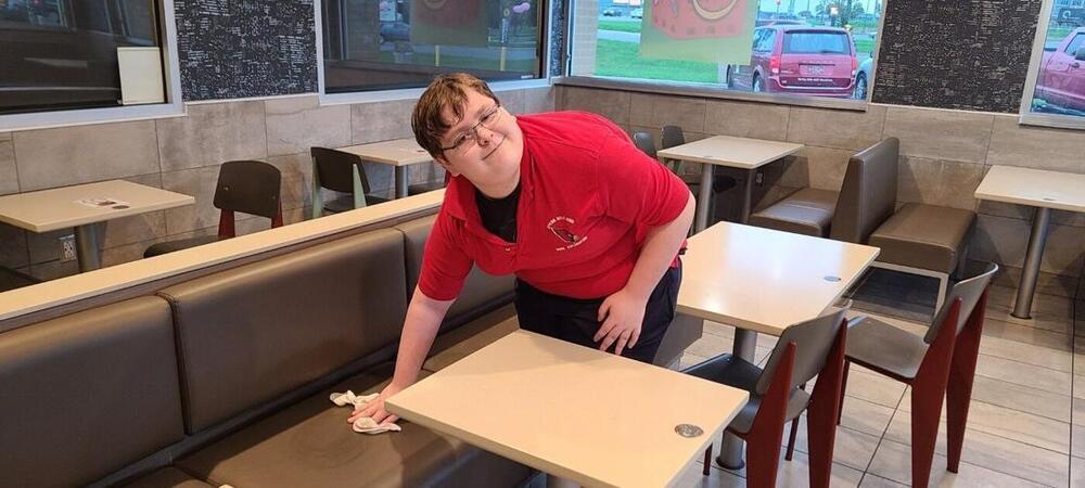 image of student wiping a table