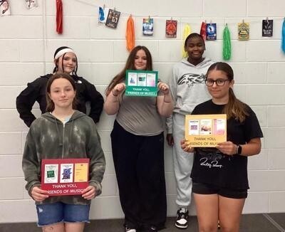 Some of the Mountain Ridge Middle School  choir students holding thank you notes for the new sheet music