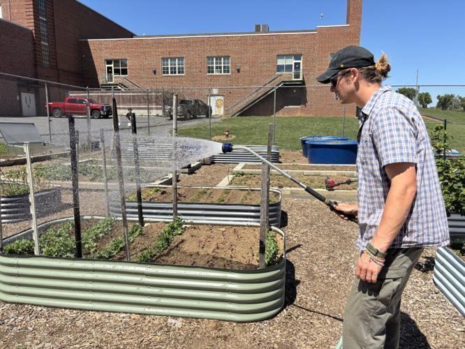 Martinsburg High School social studies teacher Derek Gallagher waters the plants at the Martinsburg High School wellness space.