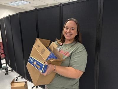 Brittany Viands holding a box of pasta for the Community Meal at Musselman High School