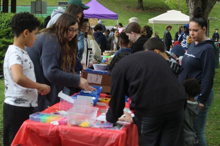 students at a fair looking at items on a table
