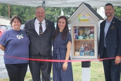 Vaylee Olack cuts a ribbon for her new Blessing Box, located on Stephen Street