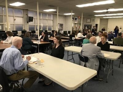 Community member conduct mock interviews with 11th-grade students
