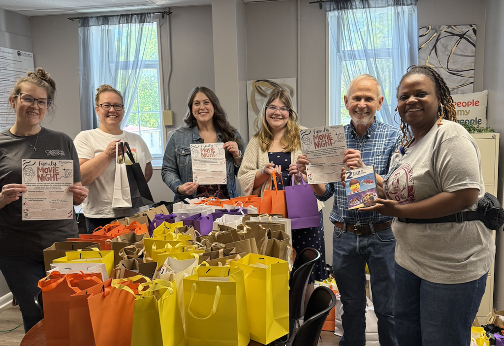Ms. Ballard and Home Society staff presenting movie goodies. 