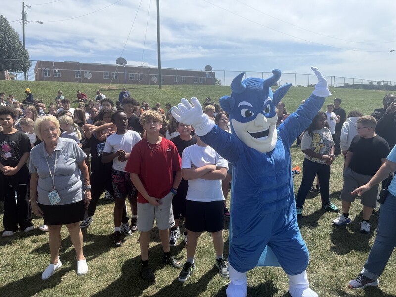 the blue devil with a group of students at the beginning pep rally
