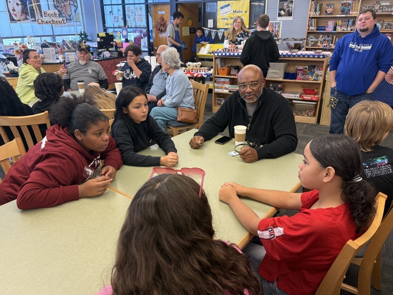 Students sitting around a table with a veteran