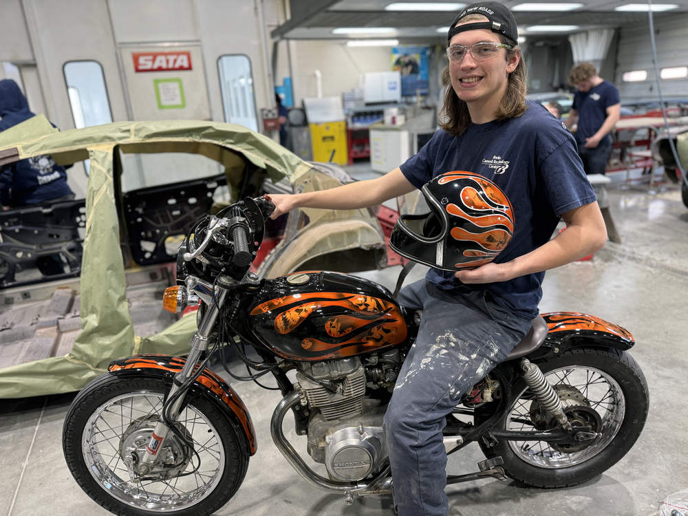 Student from Automotive Collision Repair sitting on a motorcycle