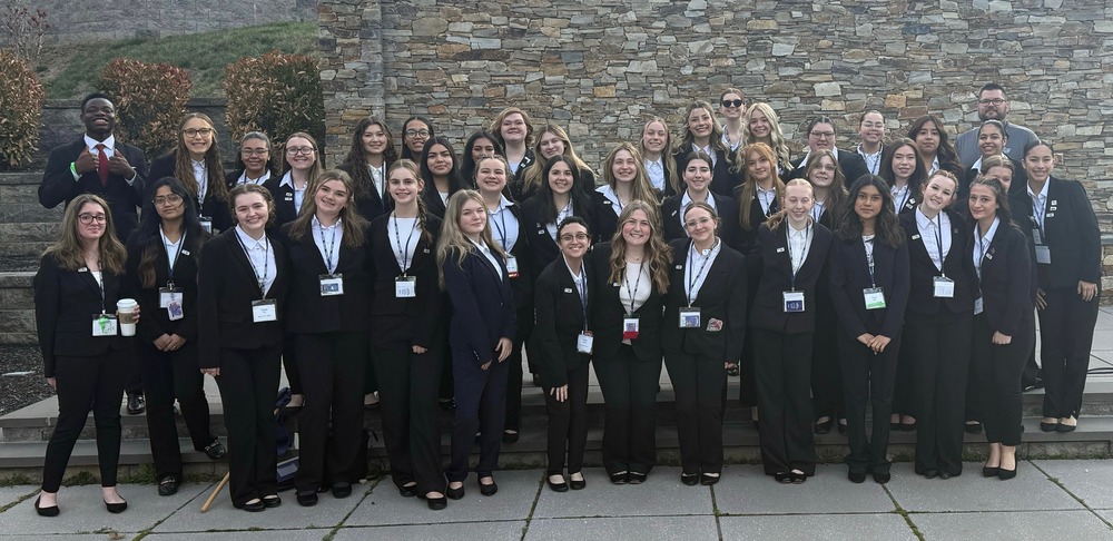 A group of students dressed in business suits stand together