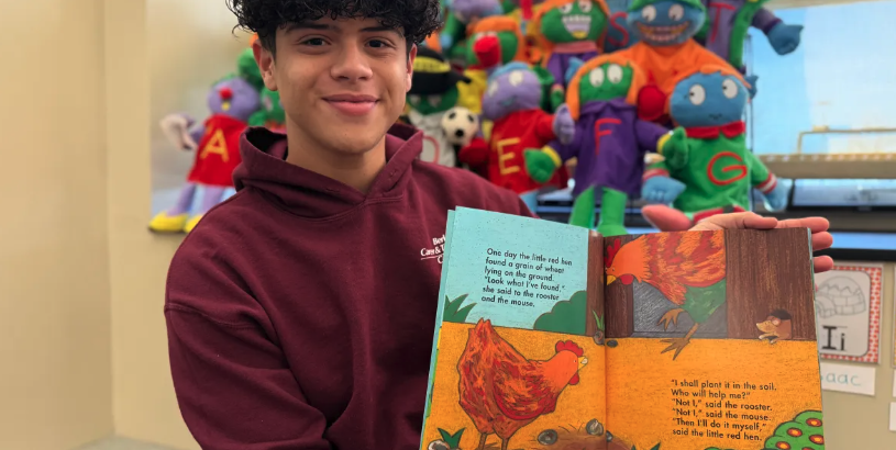 Jacob Guilbe, a Level 3 Early Childhood Education (ECE) student at Berks Career and Technology Center (BCTC), smiling at the camera and holding an illustrated children's book.