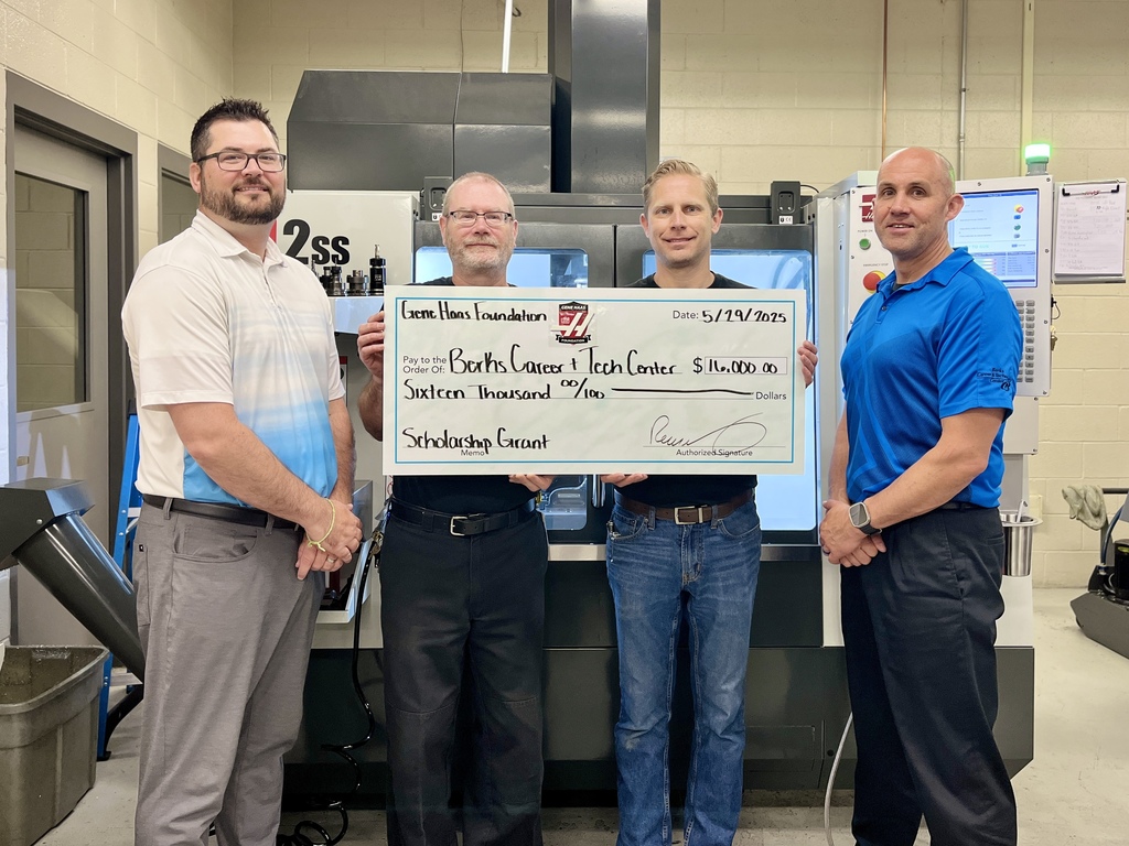 Four individuals stand in front of a large industrial machine, holding an oversized check. The check is from the Gene Haas Foundation, dated May 19, 2023, and made out to Berks Career & Tech Center for $16,000.00 as a scholarship grant.