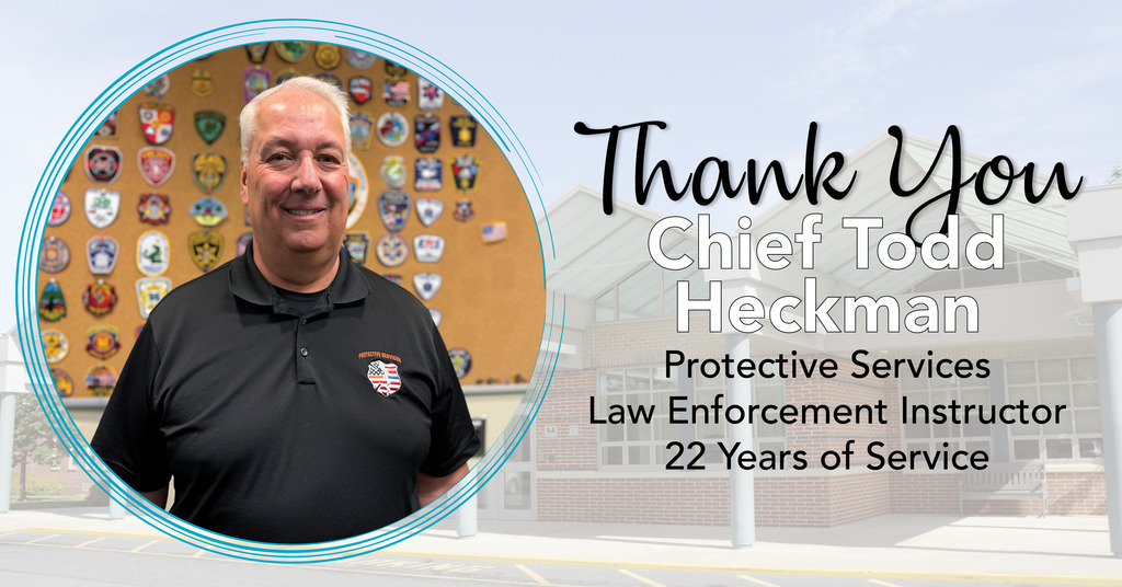 A man stands in front of a wall covered with various law enforcement patches. He is wearing a black polo shirt with an embroidered badge on the left side. To the right, text reads: "Thank You Chief Todd Heckman, Protective Services Law Enforcement Instructor, 22 years of Service.