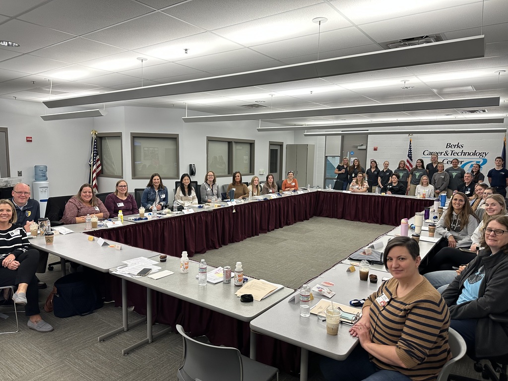 Administrators, counselors, and teachers from BCTC’s sending districts gather around a large conference table in a BCTC meeting room. Smiling participants face the camera with the Berks Career & Technology Center logo visible on the wall.