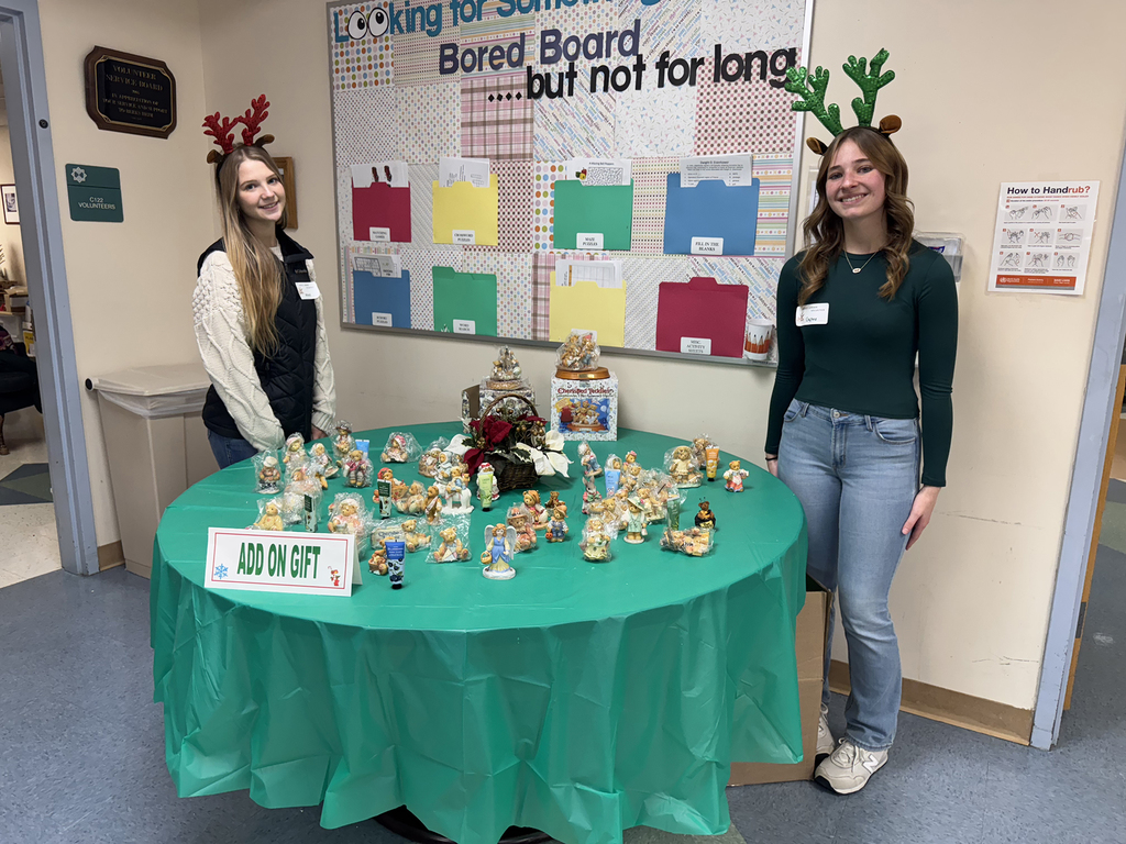 Group of Health Occupations students pose together in front of a balloon arch, wearing festive sweaters and holiday accessories.