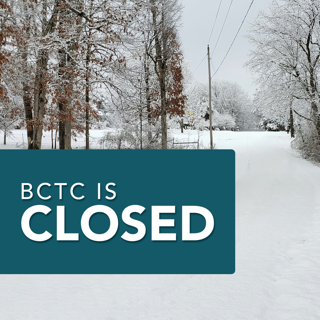 A snowy rural road lined with trees covered in fresh snow. Brown leaves cling to a few branches while power lines run along the right side of the road. In the foreground, a teal rectangular banner displays white text that reads, “BCTC IS CLOSED.”