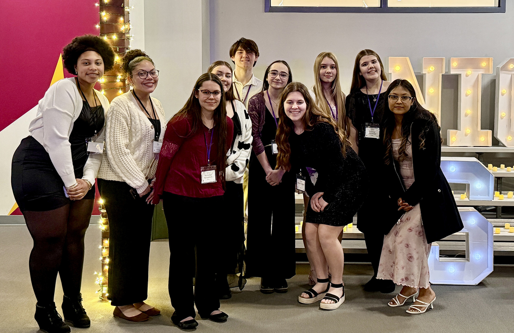 A group of Berks Career & Technology Center students pose together at the Night to Shine event, wearing name badges and formal attire, volunteering in support of adults and teens with special needs.